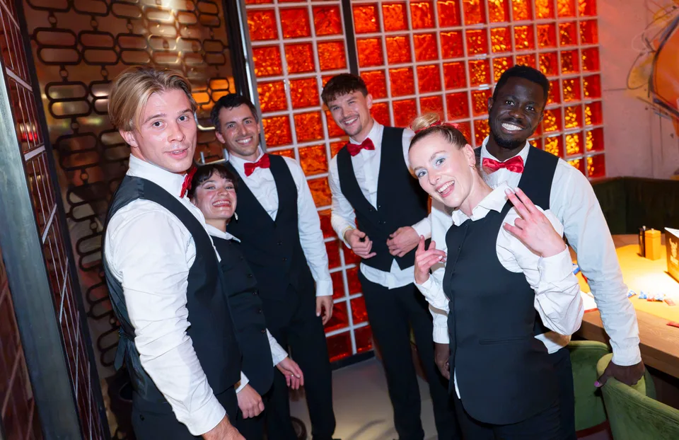 The Show Waiters team in waiter attire together after a performance.