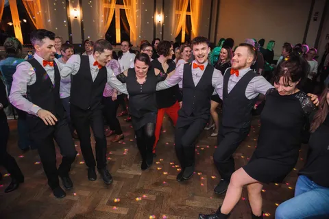 The show waiters and guests dance together on the dance floor.